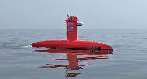 The red DriX ASV cruising through calm water.