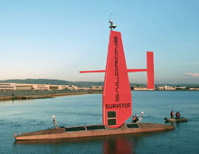 Saildrone in San Francisco Bay with a worker aboard and two people in a zodiac off the stern.
